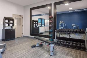 einen Fitnessraum mit einem Spiegel, einer Bank und Gewichten in der Unterkunft Hampton Inn Castle Rock in Castle Rock