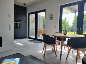 a kitchen and dining room with a table and chairs at Ferienhaus Schlossterrassen 4a in Pouch