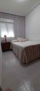 1 dormitorio con 1 cama grande y ventana en LA CASITA SERRANA, en Puerto de Béjar