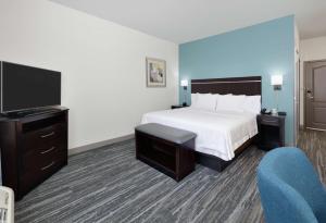 a hotel room with a bed and a flat screen tv at Hampton Inn & Suites Childress in Childress