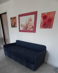 un divano blu in una stanza con foto sul muro di Appartamento Marina di Pisticci-Marconia a Marconia