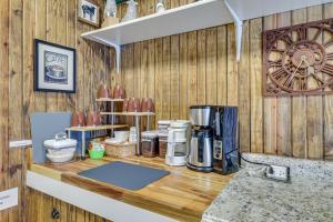 a counter with a coffee maker on a wooden wall at Charming Converted Railcar Studio in Joplin! in Joplin