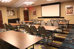 a conference room with tables and chairs and a screen at Hampton Inn Cotulla in Cotulla