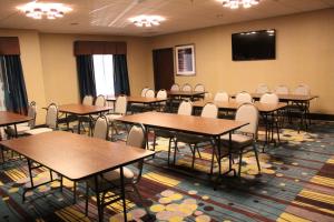 uma sala de conferências com mesas e cadeiras e uma televisão de ecrã plano em Hampton Inn Cotulla em Cotulla