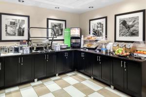 a breakfast buffet in a room with black cabinets at Hampton Inn Miami/Dadeland in South Miami