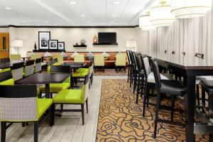 a restaurant with tables and chairs and a bar at Hampton Inn Miami/Dadeland in South Miami