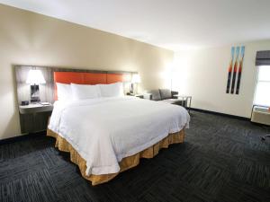 um quarto de hotel com uma cama grande e uma cadeira em Hampton Inn Saint Augustine-I-95 em Saint Augustine