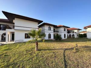 a palm tree in front of a house at Havuzlu Sitede Müstakil Villa in Manavgat