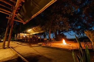 a fire burns in a patio at night at ASKIESBOS - Samochima Bush Camp in Shakawe