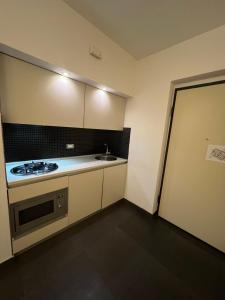 una piccola cucina con piano cottura e lavandino di Qatar Apartment a Cosenza