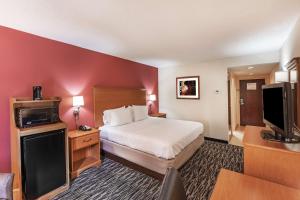 a hotel room with a bed and a flat screen tv at Hampton Inn Aiken in Aiken