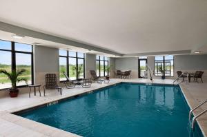 - une piscine dans un hôtel avec des tables et des chaises dans l'établissement Hampton Inn Belton/Kansas City, à Belton