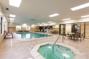 una gran piscina con bañera de hidromasaje, mesas y sillas en Hampton Inn Port Huron, en Port Huron