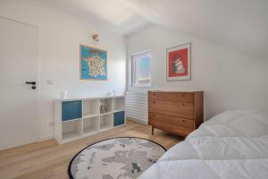 a white bedroom with a bed and a wooden dresser at Maison moderne avec jardin pour 8 à La Baule in La Baule