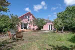a pink house with two chairs in the yard at Maison moderne avec jardin pour 8 à La Baule in La Baule