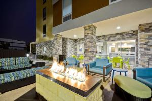 Home2 Suites By Hilton Maumee Toledo في ماومي: غرفة معيشة مع حفرة نار في الوسط