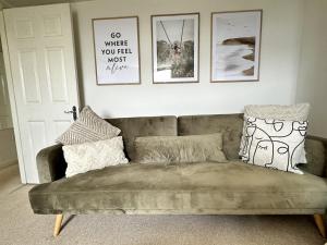 a couch in a living room with pictures on the wall at Central City Beach Pad in Brighton & Hove