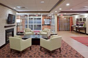 a lobby with chairs and a table and a fireplace at Hampton Inn Sturbridge in Sturbridge