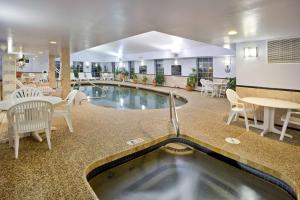 uma piscina no meio de uma sala com mesas e cadeiras em Hampton Inn Sturbridge em Sturbridge