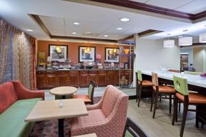 a restaurant with tables and chairs and a counter at Hampton Inn Sturbridge in Sturbridge