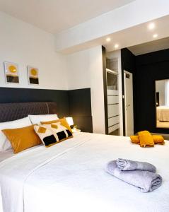 1 dormitorio con 1 cama blanca grande con almohadas amarillas en Elli’s Home, en Tesalónica