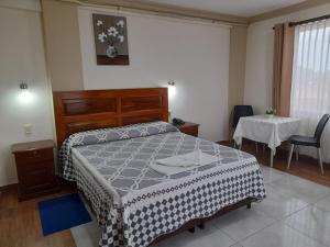 1 dormitorio con cama, mesa y mesa en L J en Trinidad