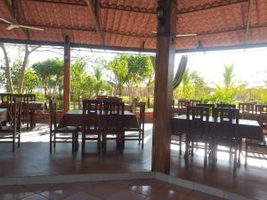 ein Esszimmer mit Tischen und Stühlen und einem großen Fenster in der Unterkunft L J in Trinidad
