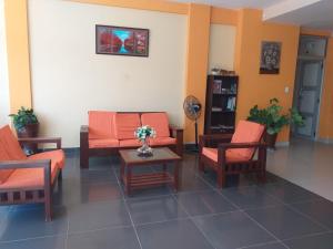 una sala de espera con sillas naranjas y una mesa en L J en Trinidad