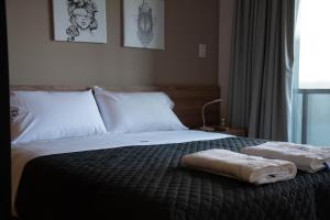 a bedroom with a bed with two towels on it at ANDÉN by FMA Coliving in Salta +39 photos