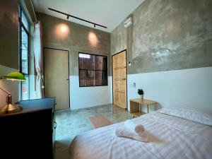 a bedroom with a bed and a desk and a window at DoSomething Guest House 5 in Ipoh