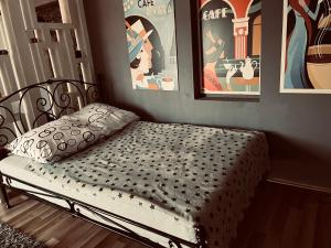 uma cama num quarto com cartazes na parede em Bubinga em Kruševac