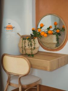 un miroir sur une étagère avec une chaise et un panier orange dans l'établissement iRest Orange Tay Ho Lakeside Apartment, à Hanoï