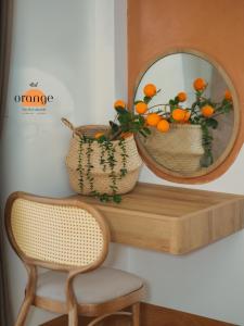 a mirror on a shelf with a chair and an orange basket at iRest Orange Tay Ho Lakeside Apartment in Hanoi