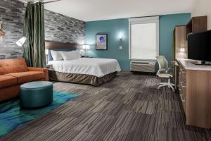 a hotel room with a bed and a desk at Home2 Suites By Hilton Dayton Centerville in Centerville