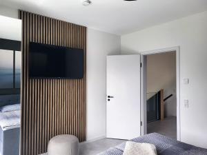 a bedroom with a flat screen tv on a wall at Ferienhaus Schlossterrassen 4b in Pouch