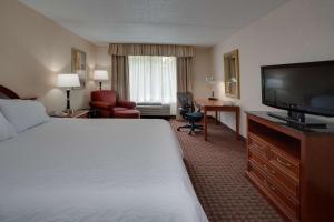 a hotel room with a bed and a flat screen tv at Hilton Garden Inn Cleveland Airport in Fairview Park