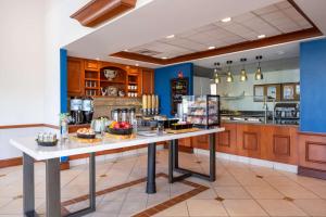 a large kitchen with a table with food on it at Hilton Garden Inn Mystic/Groton in Groton