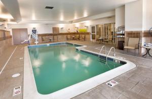 una piscina en una habitación de hotel con mesas y sillas en Homewood Suites by Hilton Newport-Middletown, en Middletown