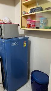 a blue refrigerator in a room with a shelf at Casa de Sanchi in Puttaparthi
