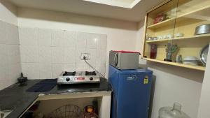a small kitchen with a stove and a microwave at Casa de Sanchi in Puttaparthi