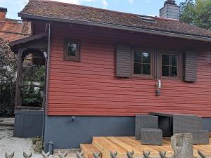 a red house with a wooden floor and windows at Ferienhaus Tinyhouse21 Wasserkuppe in Obernhausen