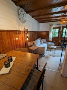 ein Wohnzimmer mit einem Tisch und einer Uhr an der Wand in der Unterkunft Ferienhaus Tinyhouse21 Wasserkuppe in Obernhausen