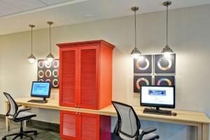 una oficina con armarios rojos y un escritorio con dos ordenadores en Home2 Suites By Hilton Meridian en Meridian