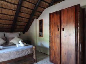 a bedroom with a bed and a wooden door at African Kruger Lodge in Marloth Park