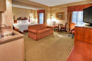 a hotel room with a bed and a living room at Hampton Inn Marion in Jacktown