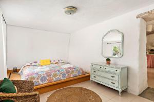 a bedroom with a bed and a mirror and a dresser at Casita Estancia d'en Carretero- Biniarroca in Es Castell