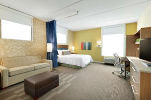 une chambre d'hôtel avec un lit et un canapé dans l'établissement Home2 Suites by Hilton Saratoga Malta, à Malta