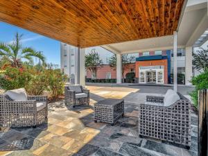 un patio con sedie e tavoli in vimini di fronte a un edificio di Hampton Inn and Suites Lufkin a Lufkin