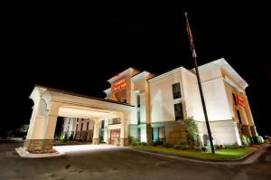 ein großes weißes Gebäude mit einem Eingang in der Nacht in der Unterkunft Hampton Inn & Suites Tifton in Tifton