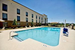 a large swimming pool in front of a hotel at Hampton Inn & Suites Tifton in Tifton